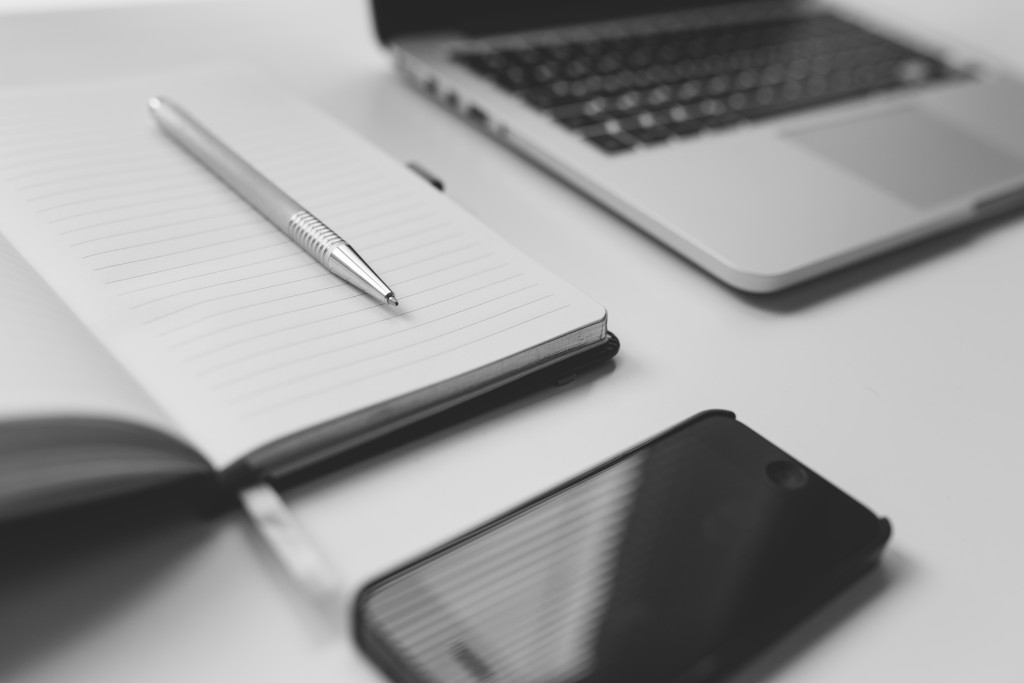 Ordinateur portable, carnet et téléphone intelligent sur un bureau.